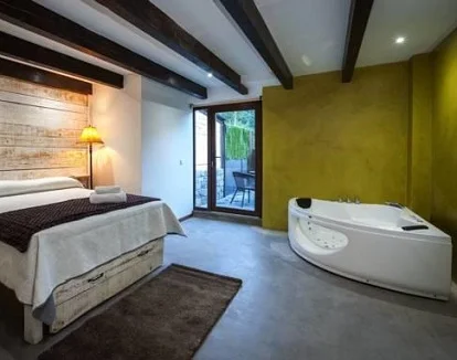 Foto de la Habitación Triple con terraza donde vemos el jacuzzi junto a la cama
