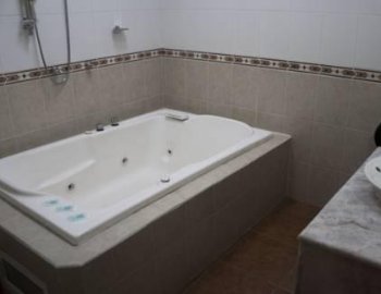 Foto y detalle de jacuzzi en la Habitación con cama extragrande y bañera de hidromasaje.
