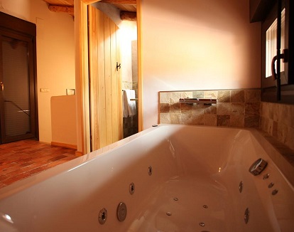 Foto de la bañera de hidromasaje junto a la cama en la casa rural El Zaguán en Albarracín