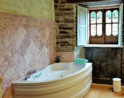 Habitacion doble con bañera de hidromasaje en el hotel rural A Casa Do Retratista. La mayoría de habitaciones dobles disponen de bañera de hidromasaje con su propio estilo.