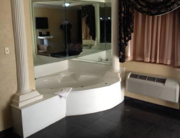Jacuzzi privado en la Suite con cama grande y bañera de hidromasaje.