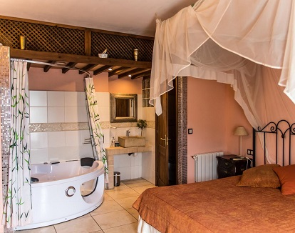 Suite con bañera de hidromasaje doble en hotel rual Pasteral en La Cellera de Ter en la provincia de Girona
