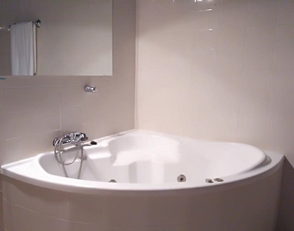 Bañera de hidromasaje en el baño de la suite del hotel rural Las Cumbres Venta Del Alto en la población El Garrobo en la provincia de Sevilla