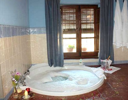 La suite con bañera de hidromasaje en el hotel rural La Fuente del Sol y con vistas al campo.