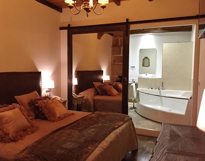 Suite deluxe con chimenea y jacuzzi en la habitación. Más de 50 metros cuadrados en una suite con decoración rústica muy elegante.