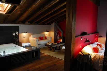 Foto del jacuzzi junto a la cama y frente a la chimenea que se encuentra en la suite junior en Relais du Silence Hotel Rural Iribarnia