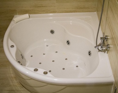 Bañera de hidromasaje en el baño de la suite con terraza en el Hotel Rural el Nacimiento de Deifontes en la provincia de Granada