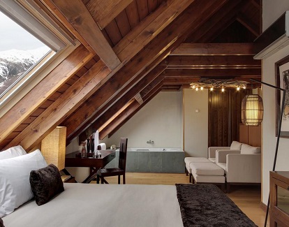 suite superior con el jacuzzi privado al fondo de la habitación y todo bajo techo aboardillado en Rafaelhoteles by La Pleta