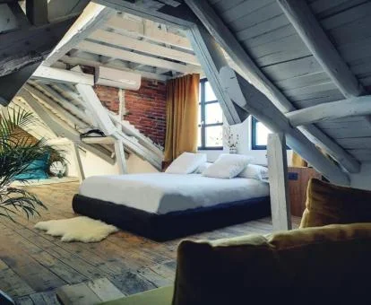 Una de las preciosas suites de este establecimiento ideal para parejas, con estilo abuhardillado y decoración con madera y ladrillo.