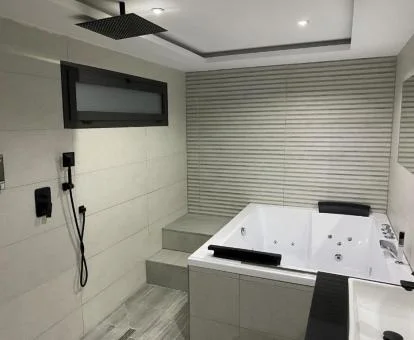 Amplia bañera de hidromasaje privada de uno de los apartamentos deluxe del establecimiento.