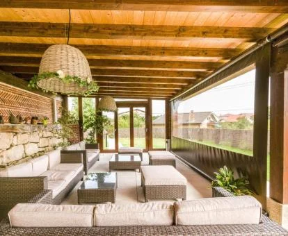 Preciosa zona de estar bajo porche con vistas a los jardines del hotel.