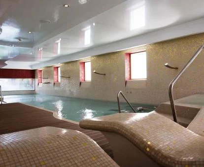 Piscina cubierta con zona de relajación del spa.