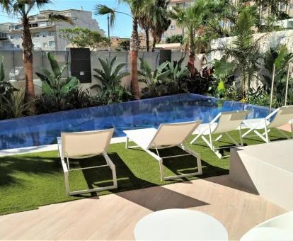 Agradable terraza solarium con piscina rodeada de vegetación de este establecimiento.