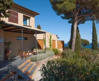 Edificio de este hotel solo para adultos con vistas al mar, jardines con árboles y porche con zonas de estar.