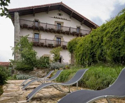 Edificio de este hotel rural con solarium y tumbonas.
