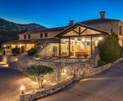 Hermoso edificio de este hotel rústico con iluminación nocturna.