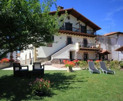 Bonito hotel rural con jardín y zonas de estar en el exterior.