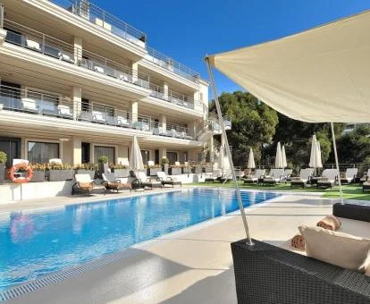 Edificio de este hotel con piscina y zonas exteriores cerca de la playa.