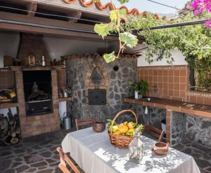 Zona exterior con mobiliario y barbacoa e este alojamiento rural.