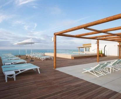 Gran terraza amueblada con piscina y vistas al mar del hotel.