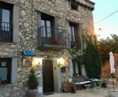 Acogedor hotel rural con mobiliario exterior.