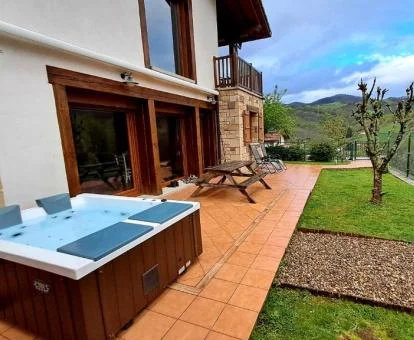 Zona exterior con jacuzzi privado, barbacoa y vistas al campo de uno de los apartamentos de este alojamiento rural.