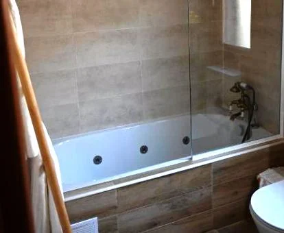 Bañera de hidromasaje privada del baño de este apartamento rural.