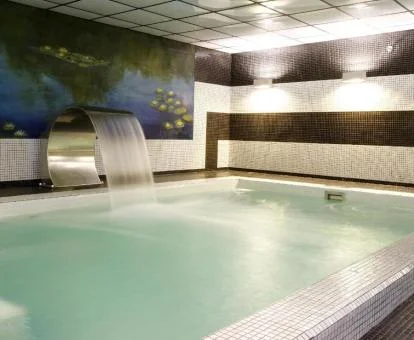 Piscina cubierta con chorros del spa del alojamiento.