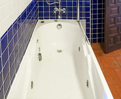 Baño con bañera de hidromasaje privada de este acogedor apartamento.