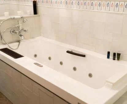 Amplia bañera de hidromasaje privada del apartamento de dos niveles de este establecimiento.