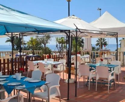 Agradable terraza con comedores exteriores y vistas al mar del hotel.