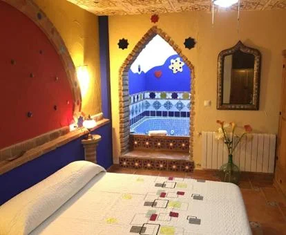 Precioso dormitorio de la suite con bañera de hidromasaje privada cerca de la cama.