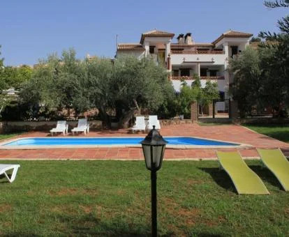 Complejo de apartamentos rurales con piscina rodeada de jardines.