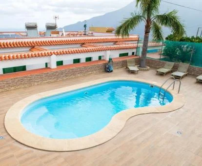 Acogedora terraza solarium con piscina de este complejo de apartamentos.