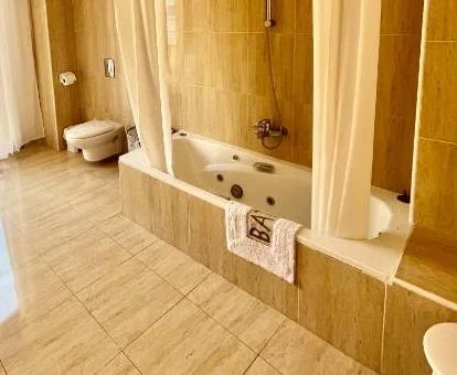 Bañera de hidromasaje privada en el baño del apartamento superior del establecimiento.