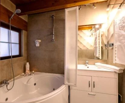 Bañera de hidromasaje privada en el baño del apartamento loft de este establecimiento.