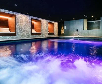 Piscina cubierta con elementos de hidroterapia del spa del hotel.