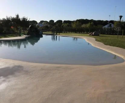 Amplia piscina de tipo laguna rodeada de naturaleza de este hotel con encanto.