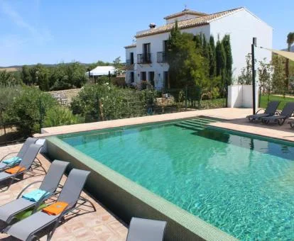 Alojamiento rural con piscina y mobiliario exterior en un entorno tranquilo.