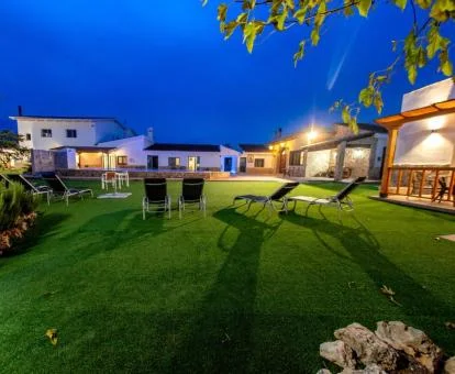 Amplia zona exterior ajardinada con mobiliario exterior y piscina de este hotel solo para adultos.