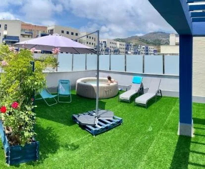 Amplia terraza privada con jacuzzi exterior y vistas a la ciudad.