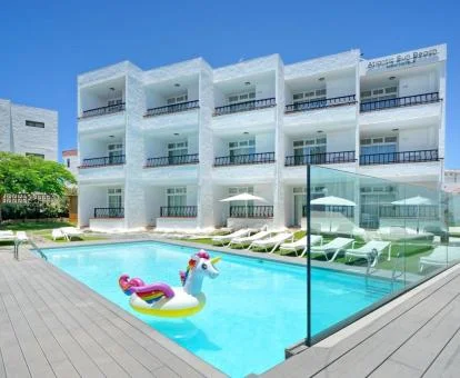 Edificio de este alojamiento solo para adultos con piscina exterior, solarium y un unicornio hinchable en la piscina.