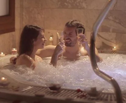 Pareja disfrutando del jacuzzi del spa privado del hotel.