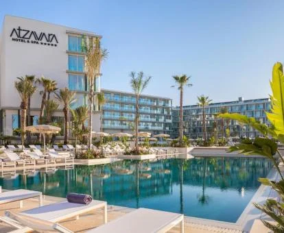 Precioso hotel romántico con gran piscina exterior rodeada de tumbonas.