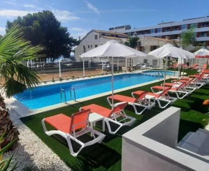 Zona exterior con piscina y solarium de este complejo de apartamentos.