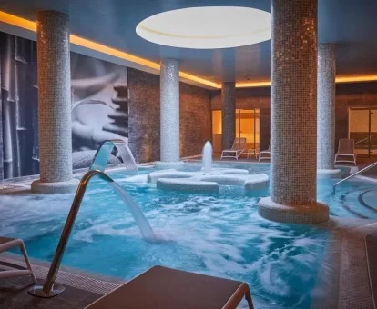 Piscina cubierta con elementos de hidroterapia del spa del hotel.