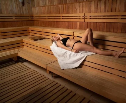 Mujer disfrutando de la sauna del spa del hotel.