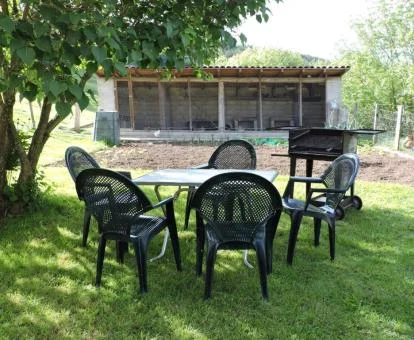 Zona exterior ajardinada con mobiliario de esta acogedora casa rural.