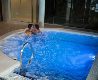 Pareja disfrutando de la zona de aguas del spa del hotel.