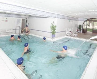 Varias personas disfrutando de la piscina de hidroterapia de las instalaciones del hotel.